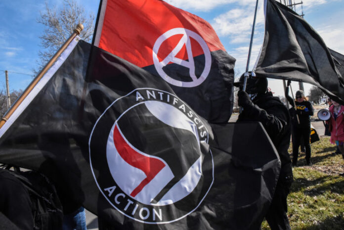 Members of the Great Lakes anti-fascist organization (Antifa) fly flags during a protest against the Alt-right outside a hotel in Warren, Michigan Antifa